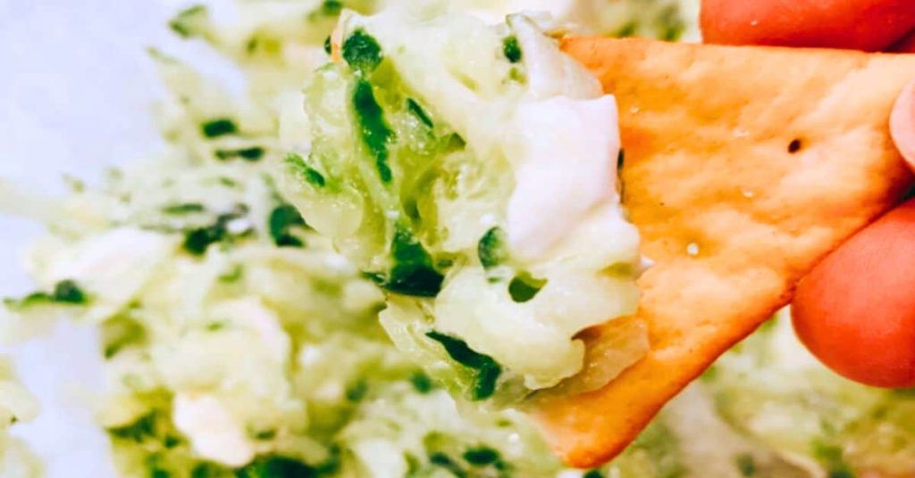 5 Minute Cream Cheese Cucumber Dip Recipe 5 Minute Cream Cheese Cucumber Dip Recipe - hand holding a cracker with fresh cucumber dip with cream cheese on it