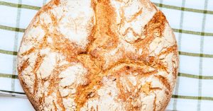 Homemade Sourdough Bread Recipe with sourdough starter on a striped dish towel on a counter